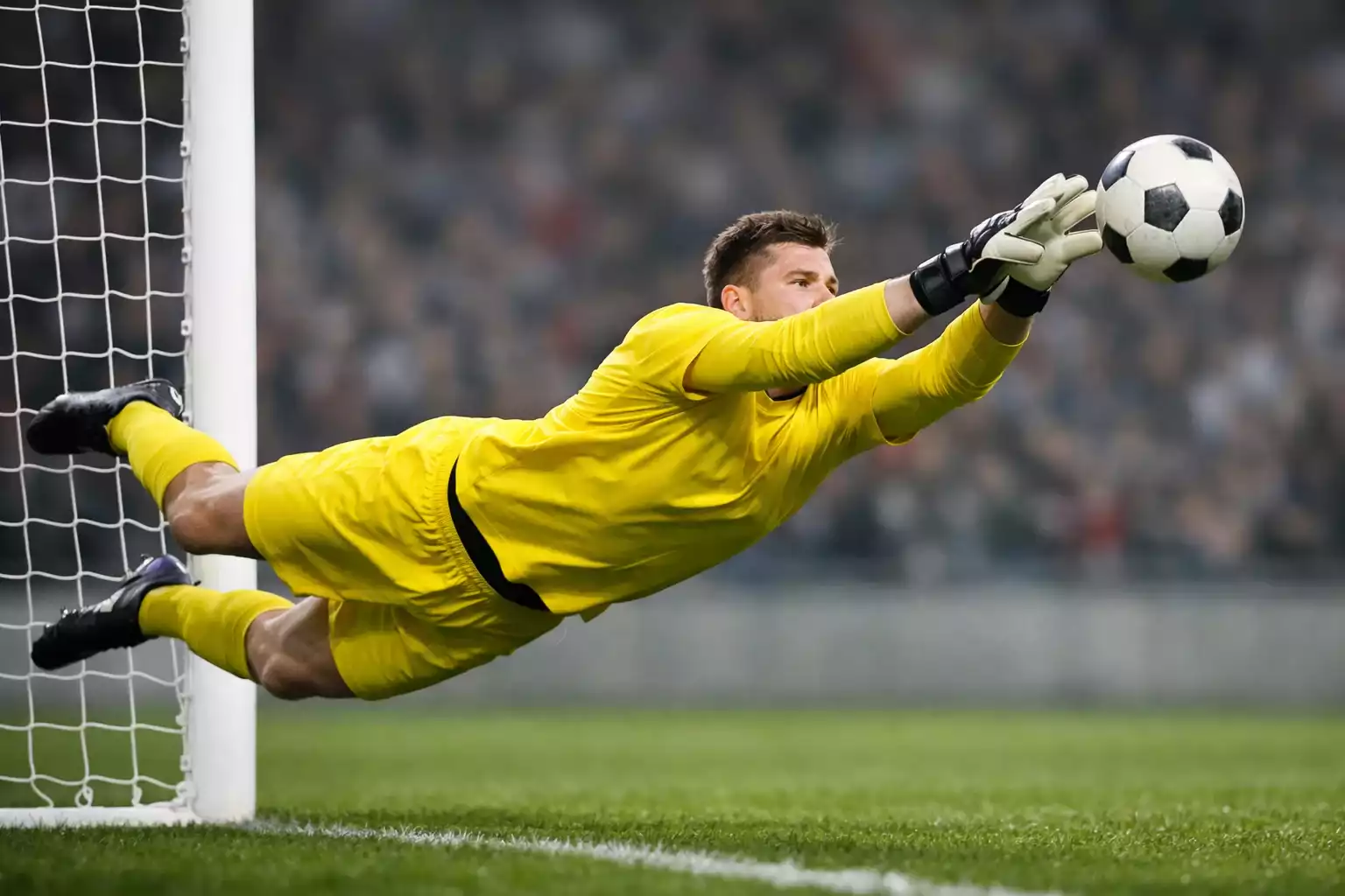 Portiere di calcio che cerca di parare un tiro