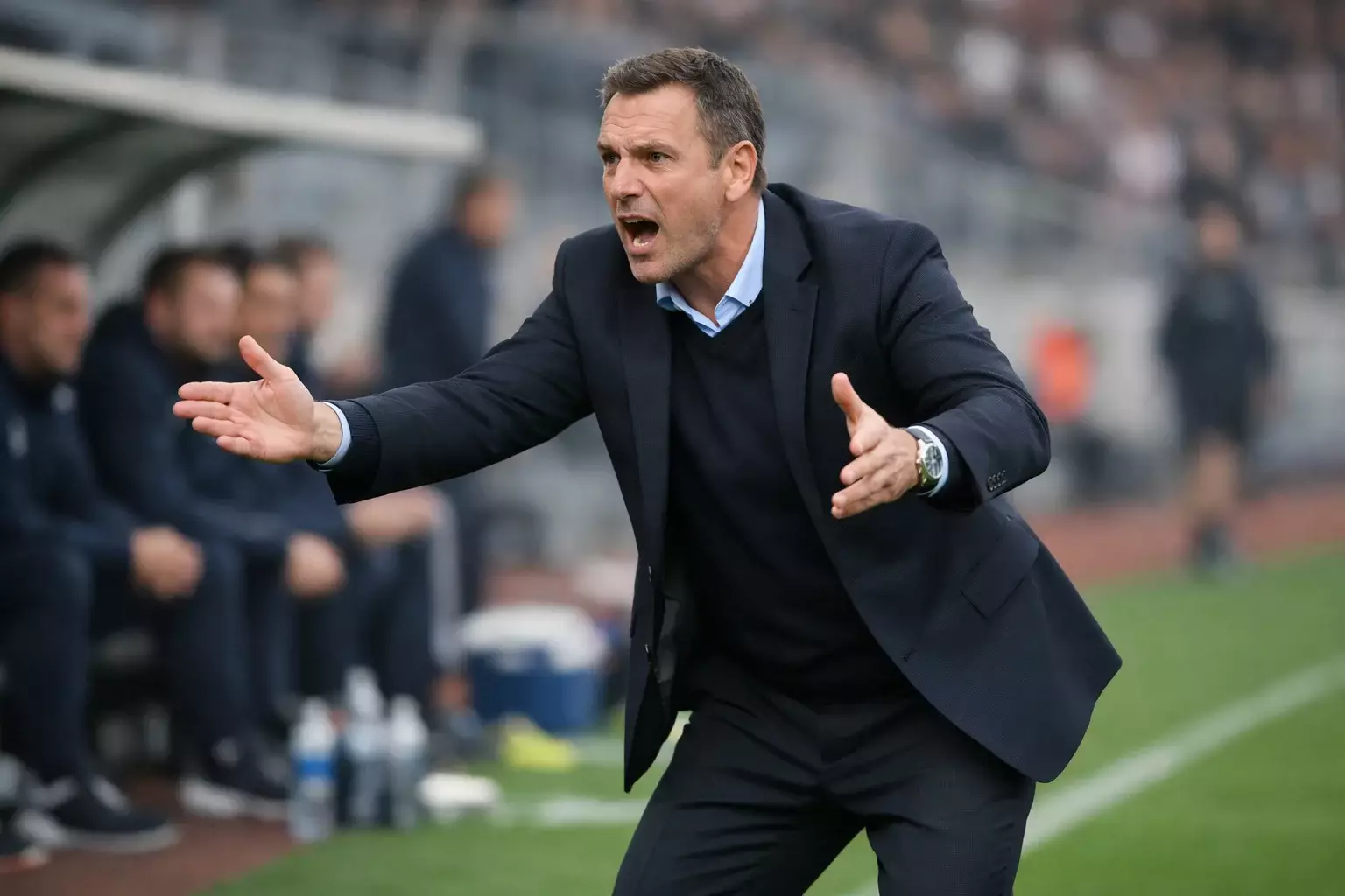 Allenatore di calcio che dà istruzioni ai giocatori dalla panchina